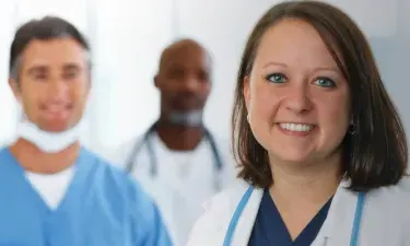 Online MSN Master's Degree Graduate Smiling with Hospital Staff